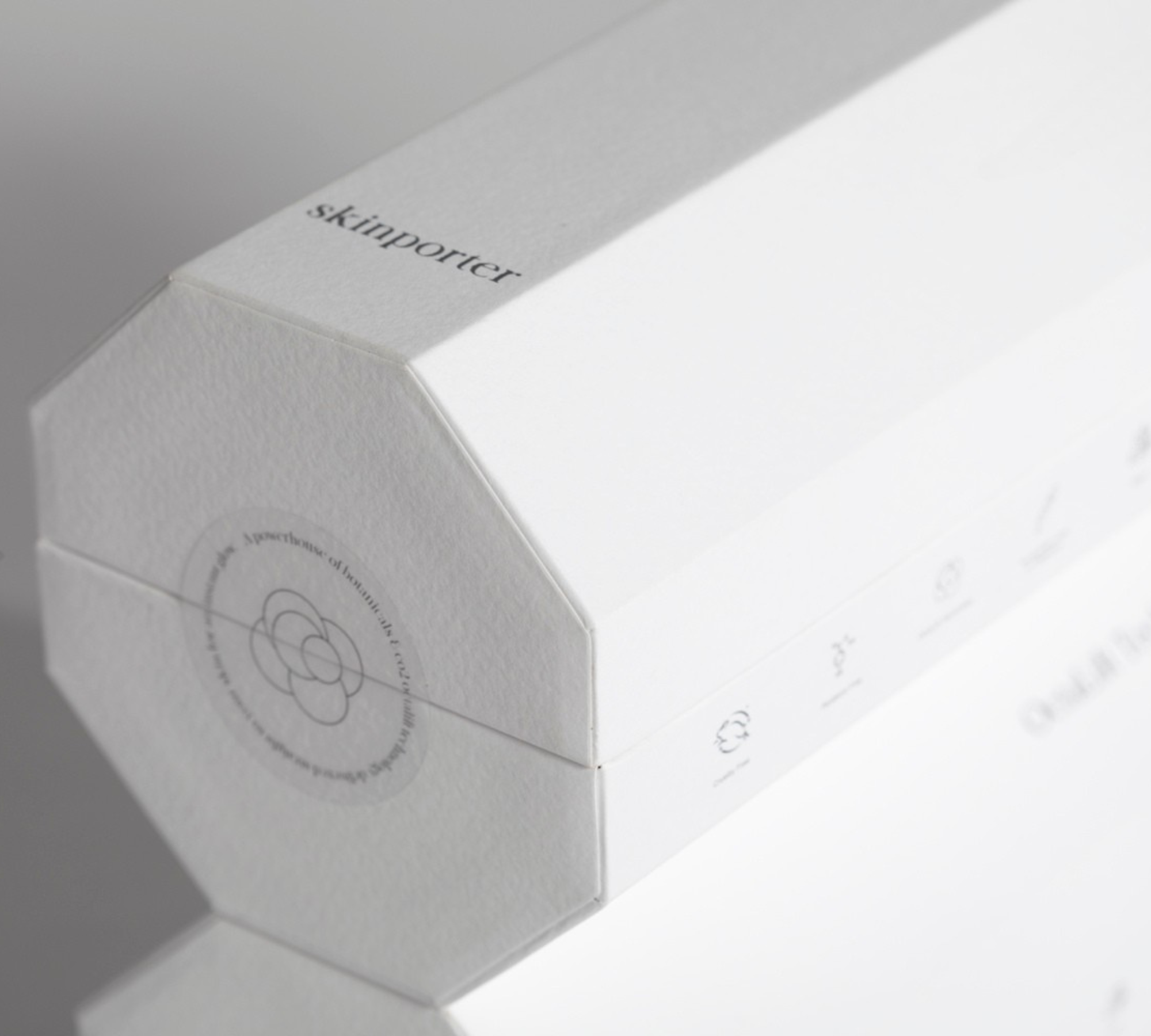 White octagonal skinporter packaging box with FSC-certified sustainable materials, embossed brand logo and O+ Complex seal — premium peptide facial skincare, responsibly packaged